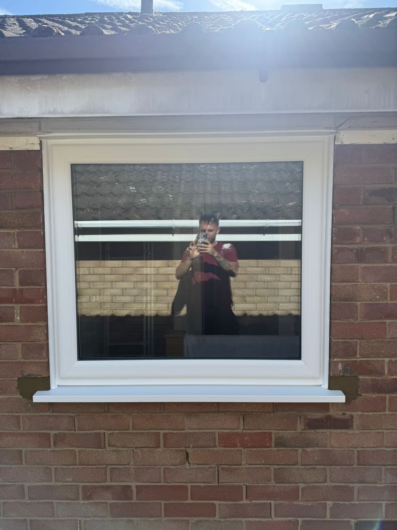 Large white uPVC fixed picture window with a new external sill in a red-brick wall